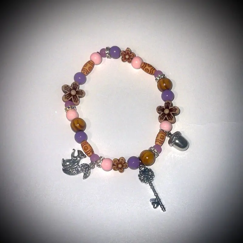 “Enchanted Keepsake" It hints at a magical, personal collection with the charms and colorful beads. Glass and Wood Beads