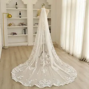 A soft tulle wedding veil featuring delicate 3D floral petals, combined with swirling vine and leaf patterns.