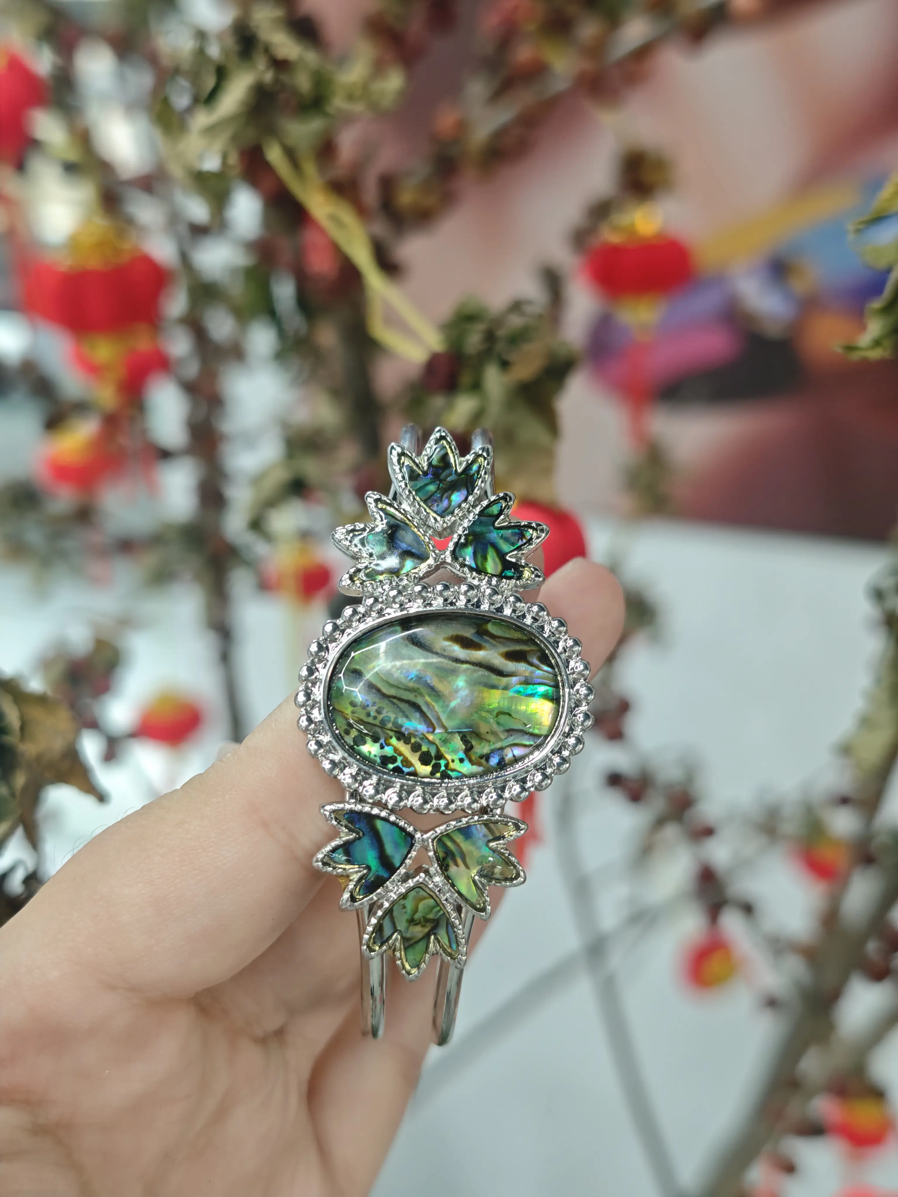 Casha(29536)gc. Abalone Shell Cuff Bangle. Oval abalone center stone with iridescent flash. Decorated with abalone maple leaves, silver bezel frame, adjustable size.