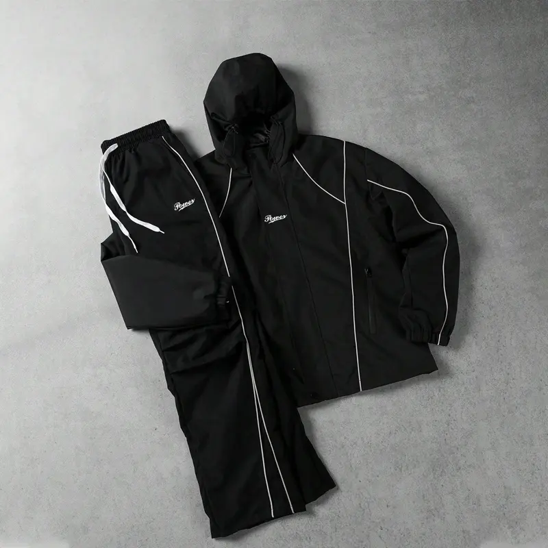 Men’s black two-piece athletic set with hood—streetwear casual style featuring contrasting white lines, minimalist letter embroidery, drawstring hood design, zippered pockets, elastic waistband cuffs, and a loose, relaxed fit. Suitable for young and middl