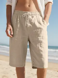 Summer breathable linen texture men’s shorts, fully elastic waistband, solid color drawstring, side pockets, lightweight crinkled cotton-feel fabric, suitable for beach/sand, commuting, and casual wear; mid-length shorts.