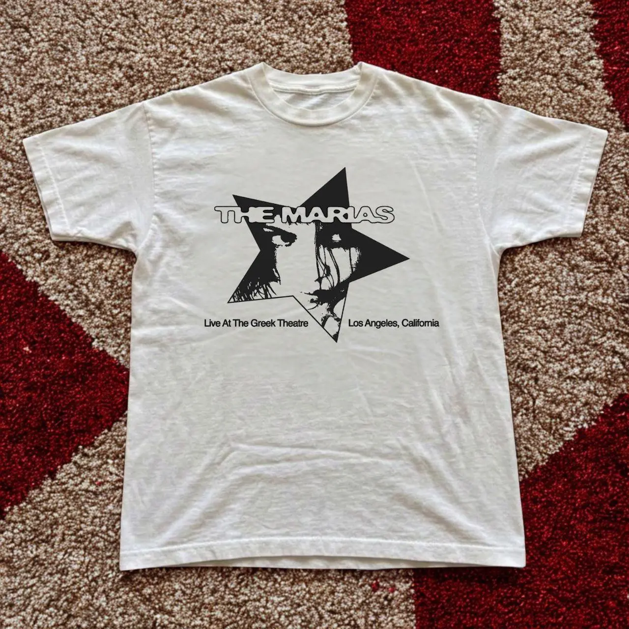 The Marías Live at The Greek Theatre graphic tee in classic white! This soft unisex t-shirt features the band’s signature star design with a striking face illustration and "Live At The Greek Theatre Los Angeles, California" text. Dreamy, artistic d