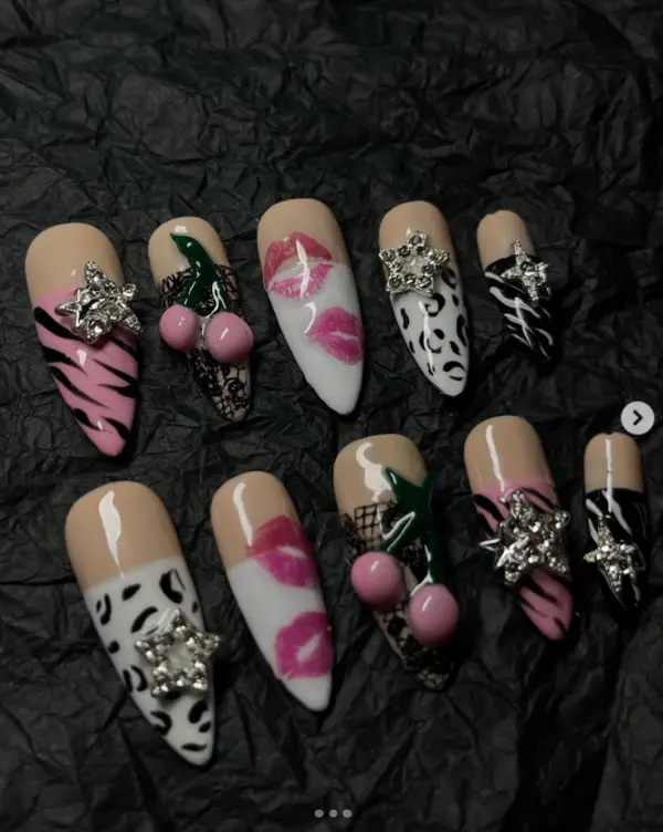 Bold glam nail art featuring animal prints, pink kisses, 3D cherries, and sparkling star gems, blending edgy patterns with playful, flirty, and luxurious vibes