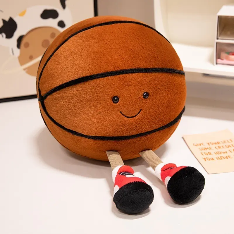 The Jellycat Amuseables Sports Basketball plush toy features a soft, textured brown fabric body with a sweet embroidered face and dangling cord legs in red and black sneakers