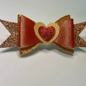 Ruby Bowtique Red and Gold Glitter Faux Leather Bow Hair Clip with Heart Centerpiece