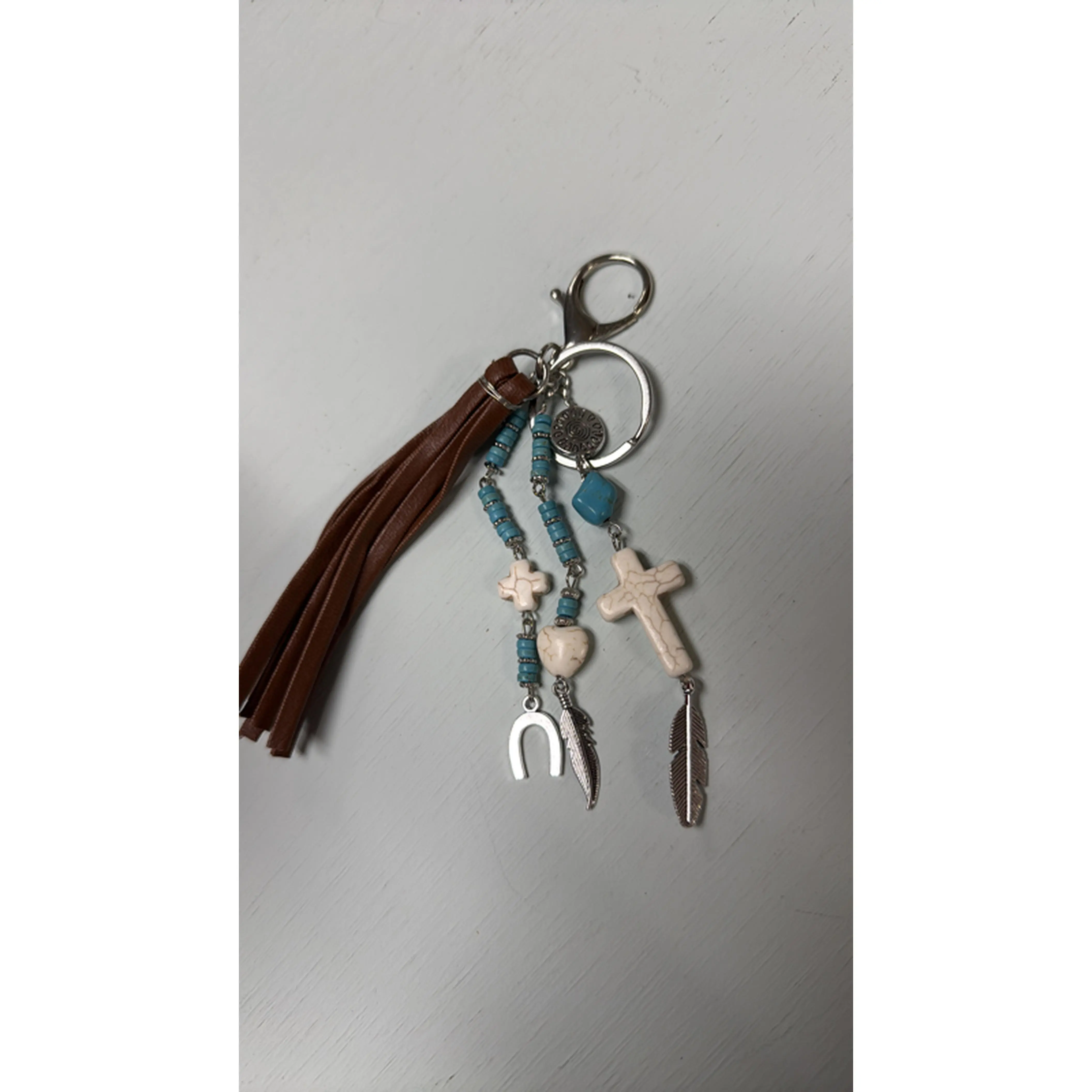 Elegant Keychain with Cross, Feather, and Horseshoe Charms, Brown Tassel, Blue Beads, and Silver Tone Hardware