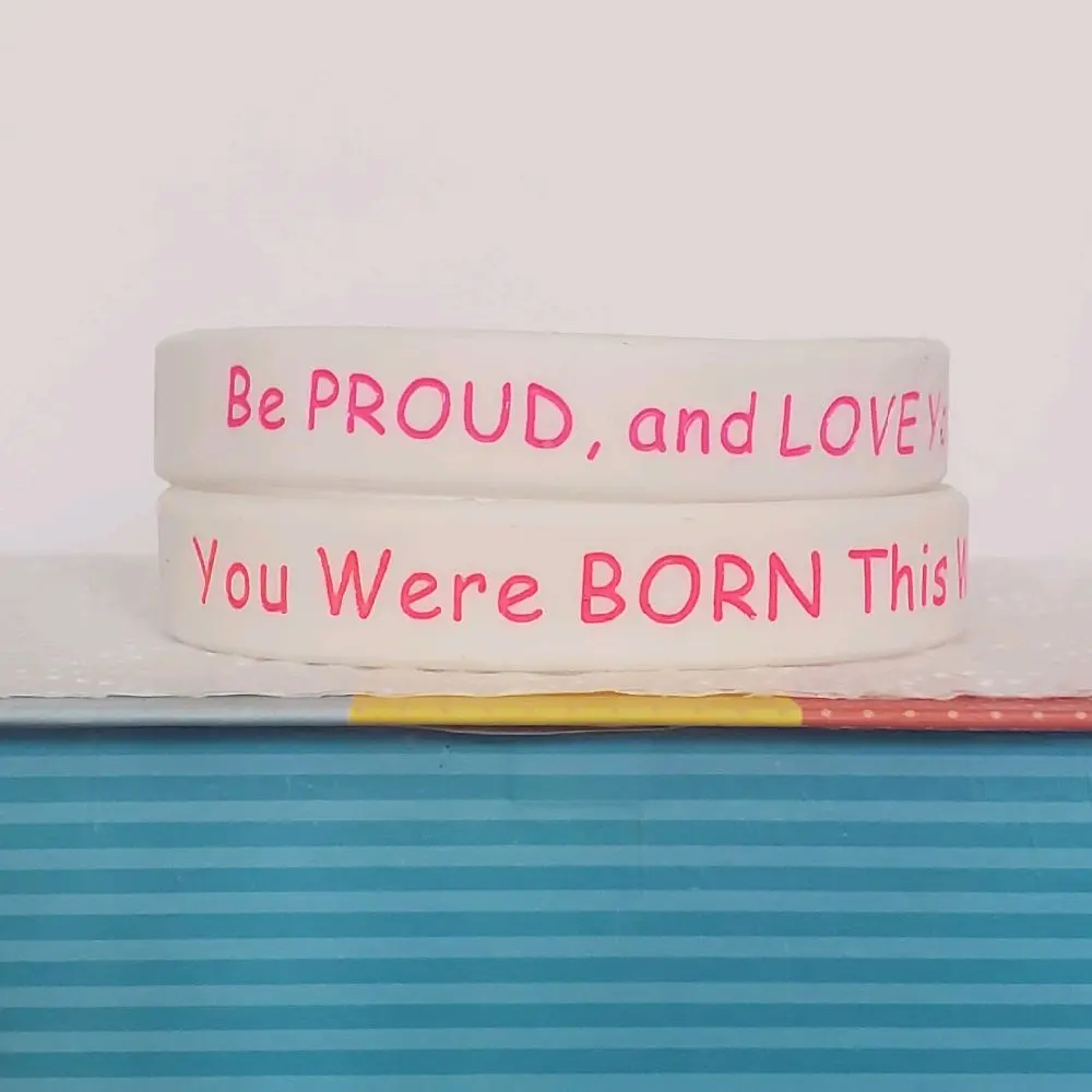 LGBTQIA+ PRIDE Silicone Wristbands saying "Be PROUD, and LOVE Yourself!" on one side, and "You Were BORN This Way!" on the other side.