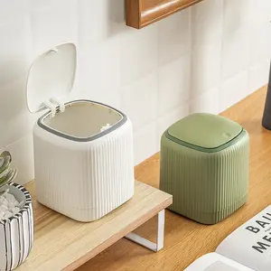 Small oval desktop trash can with push-lid design. Sturdy plastic structure ideal for bathroom, kitchen and office. Comes with 30 garbage bags, modern minimalist style for daily waste management.