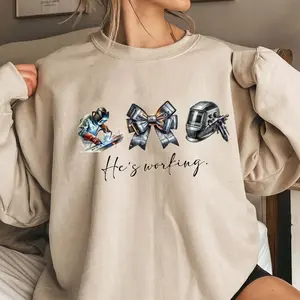 He’s Working Welder Sweatshirt – Blue Collar Wife Girlfriend Shirt, Welding Helmet Bow Graphic, Welder Wife Gift, Tradesman Family Pride Crewneck Sweatshirt
