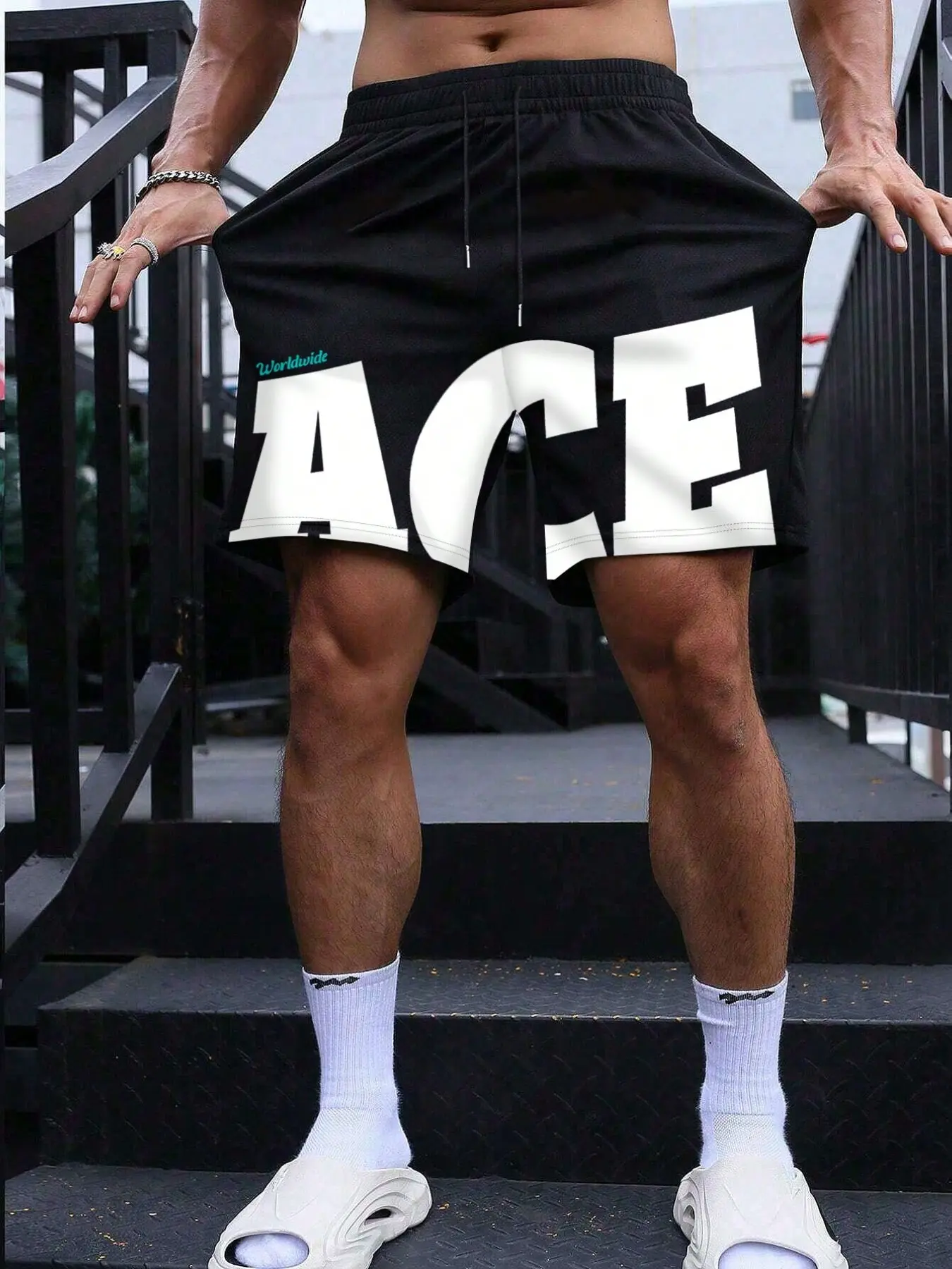 Men's black mesh fashion shorts, large white Graphic "ACE" print, "Worldwide" text detail, elastic waist with drawstring, relaxed fit, Loose, breathable fabric, streetwear style, casual summer wear, athletic aesthetic, bold statement design
