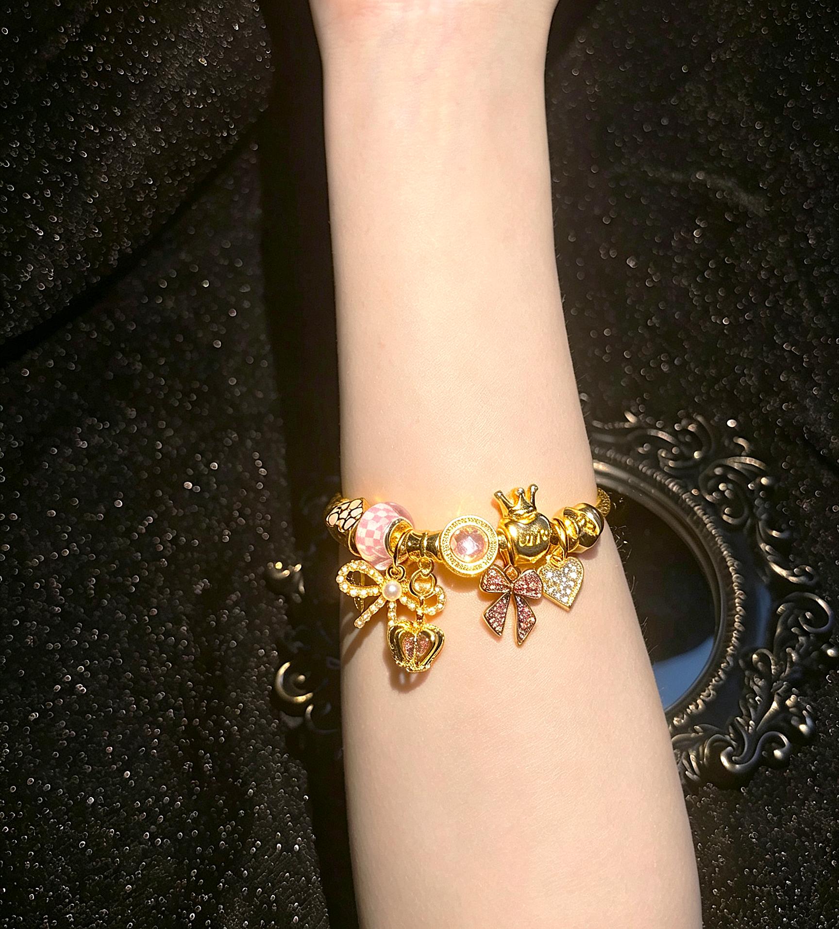Women's Cute Princess-Style Gold-Tone Adjustable Cable Bangle with Pink Checkered Bead, Bow, Crown, and Heart Dangle Charms