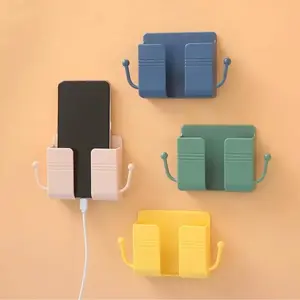 Wall-mounted mobile phone remote control charging storage box with enlarged adhesive hook for easy installation without drilling. Home storage item holder.