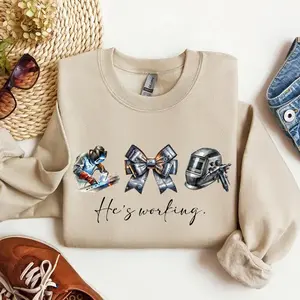 He’s Working Welder Sweatshirt – Blue Collar Wife Girlfriend Shirt, Welding Helmet Bow Graphic, Welder Wife Gift, Tradesman Family Pride Crewneck Sweatshirt