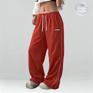 Women’s lightweight summer sports pants—thin, soft, and loose in plus sizes. Wide-leg floor-length joggers with a casual long-pant design featuring gray side stripes paired with gold decorative stripes for a comfortable athletic-casual look. Suitable as g