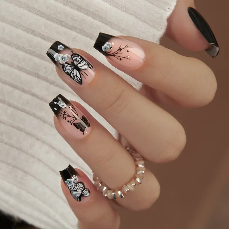 CurvLife Noir Papillon Butterfly Press-On Nails — Long Square tips in black-to-nude ombre with delicate butterfly and floral linework plus 3D pearl accents; non-toxic, durable, and reusable; quick application for chic party or everyday elegance.