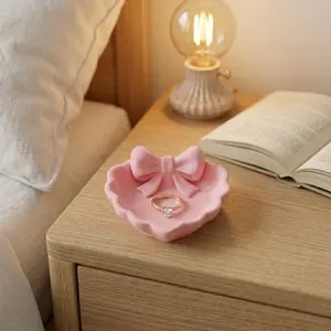 A heart-shaped jewelry tray with a pink bow, made with 3D printing process, suitable for dressing tables, sinks and for storing jewelry. It is ideal for home decoration, desks, jewelry trays.