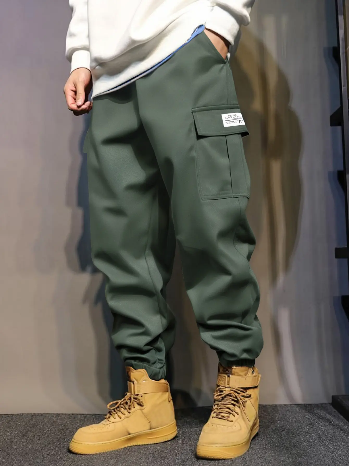 Men’s cargo jogger pants with drawstring elastic waistband, multiple flap pockets, loose street-casual fit, long length, available in three colors