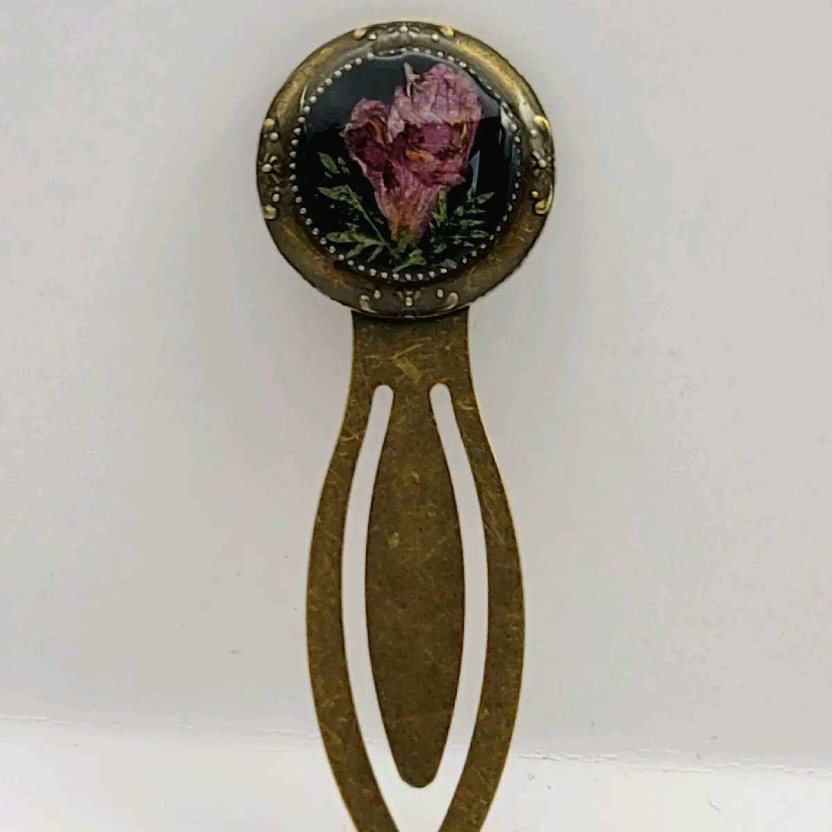 Beautiful antiqued bronze clip bookmark with real pressed purple flowers under resin. Handmade and hand pressed flowers, by me! Measurements are 3 inches long by 1 inch wide.