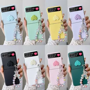 Candy-colored heart-shaped phone case with a small bear pendant bracelet. The hard PC back plate protects the phone. Compatible with Motorola Razr 2023/Razr 40