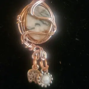 Rhodonite flat, round bead wrapped in silver plated copper wire with charms for luck!