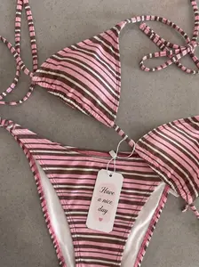 New women’s spring/summer retro pink striped bikini—tie-adjustable halter swimsuit, a beach vacation essential for summer.