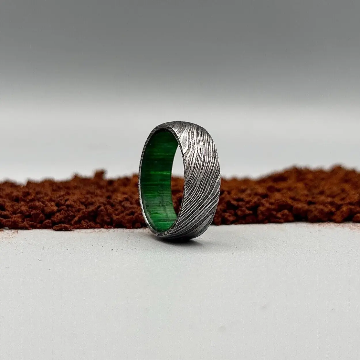 Handmade Damascus steel ring with green wood inlay—unique and timeless.