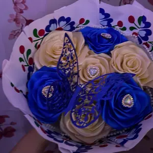 Bouquet of Blue & Cream Roses with Decorative Butterfly and Heart Accents in Floral Packaging