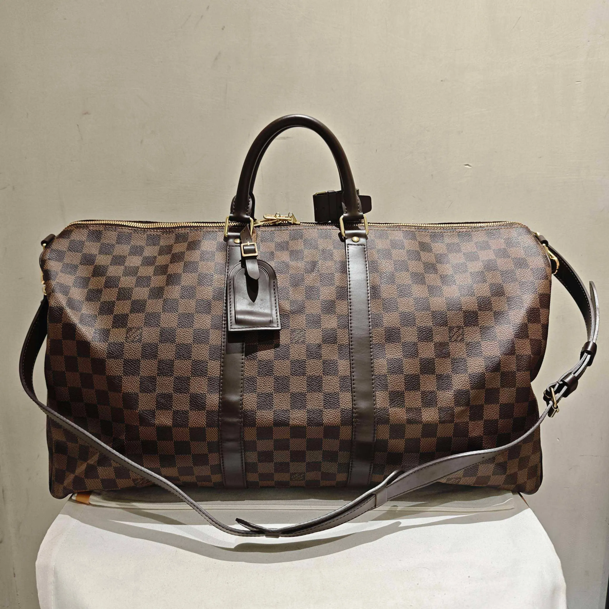Pre-owned Louis Vuitton CANVAS Travel Bags Damier Ebene Keepall Bandoulière 55, a classic travel bag featuring the signature brown checkerboard coated canvas