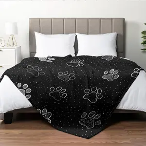 A Black Flannel Blanket With White Paw Prints On A Black Background, Featuring High-Definition Digital Printing. Suitable For All Seasons, It Can Be Used As A Sofa Throw. Made From 100% Polyester, It Is Soft And Skin-Friendly. The Perfect Gift