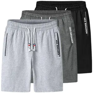 Men’s summer casual athletic shorts in gray, loose straight-leg design with an elastic waistband and drawstring; side zip pockets and lettered woven tape trim along the inseam. Comfortable and breathable, suitable for everyday wear at home or for sports.