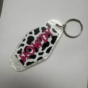 Howdy Keychain with Cow Print Design and Pink Lettering