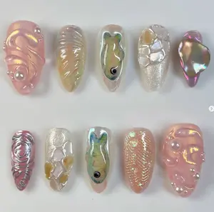 iridescent ocean inspired nails with 3d pearl accents, seashell textures, shimmering fish designs, crystal fragments and abalone effects for a dreamy mermaid vibe