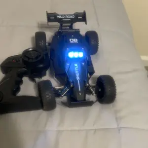 Alloy remote control off-road vehicle, 1:16 scale, 2.4GHz wireless remote control, equipped with LED headlights, available in black, blue and orange, with shock absorption function.