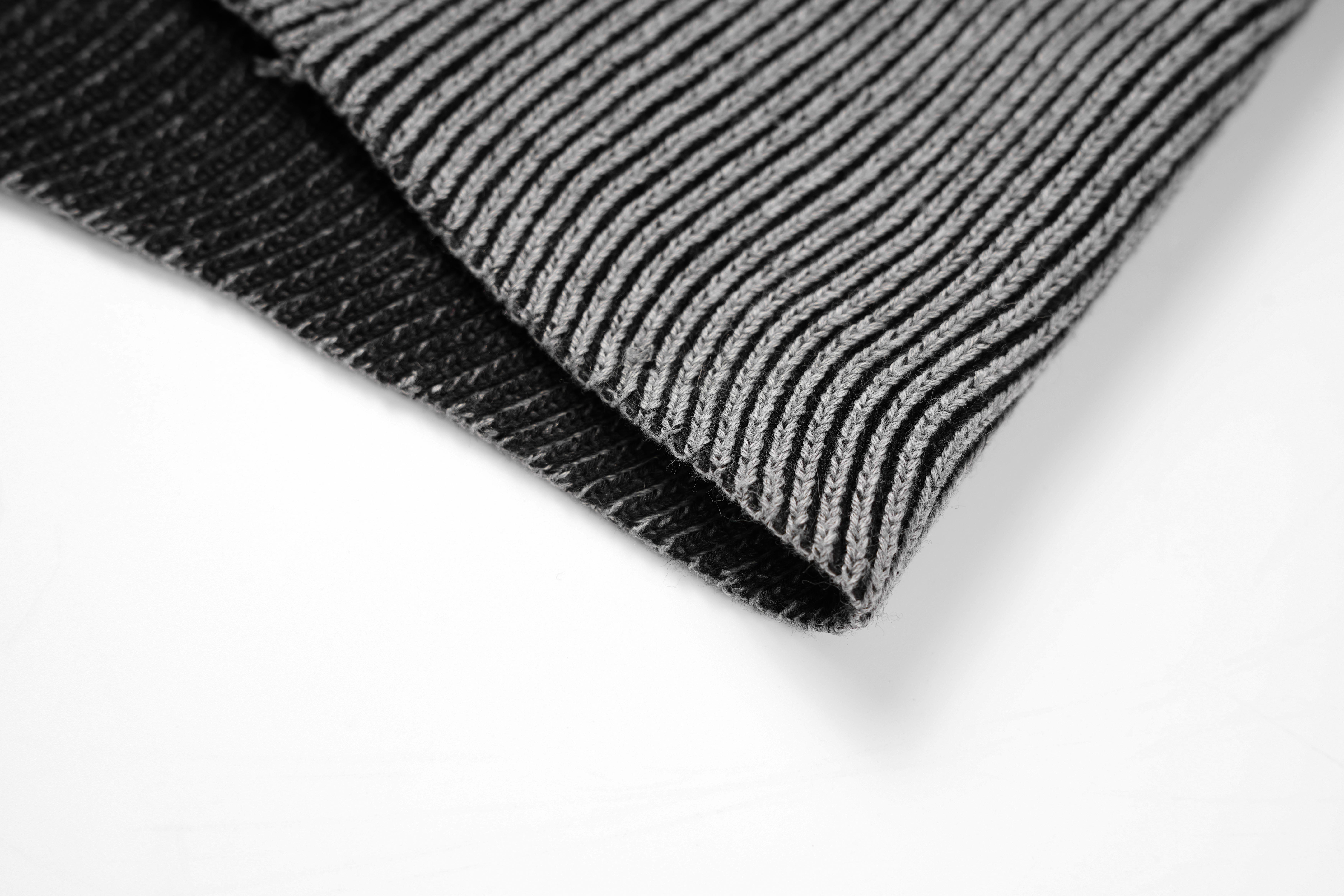 One men’s stand-collar zip-up knit sweater in a light gray color with vertical rib texture; hem features a cable pattern and raglan sleeves. Suitable for everyday commuting; clean, refined fit.