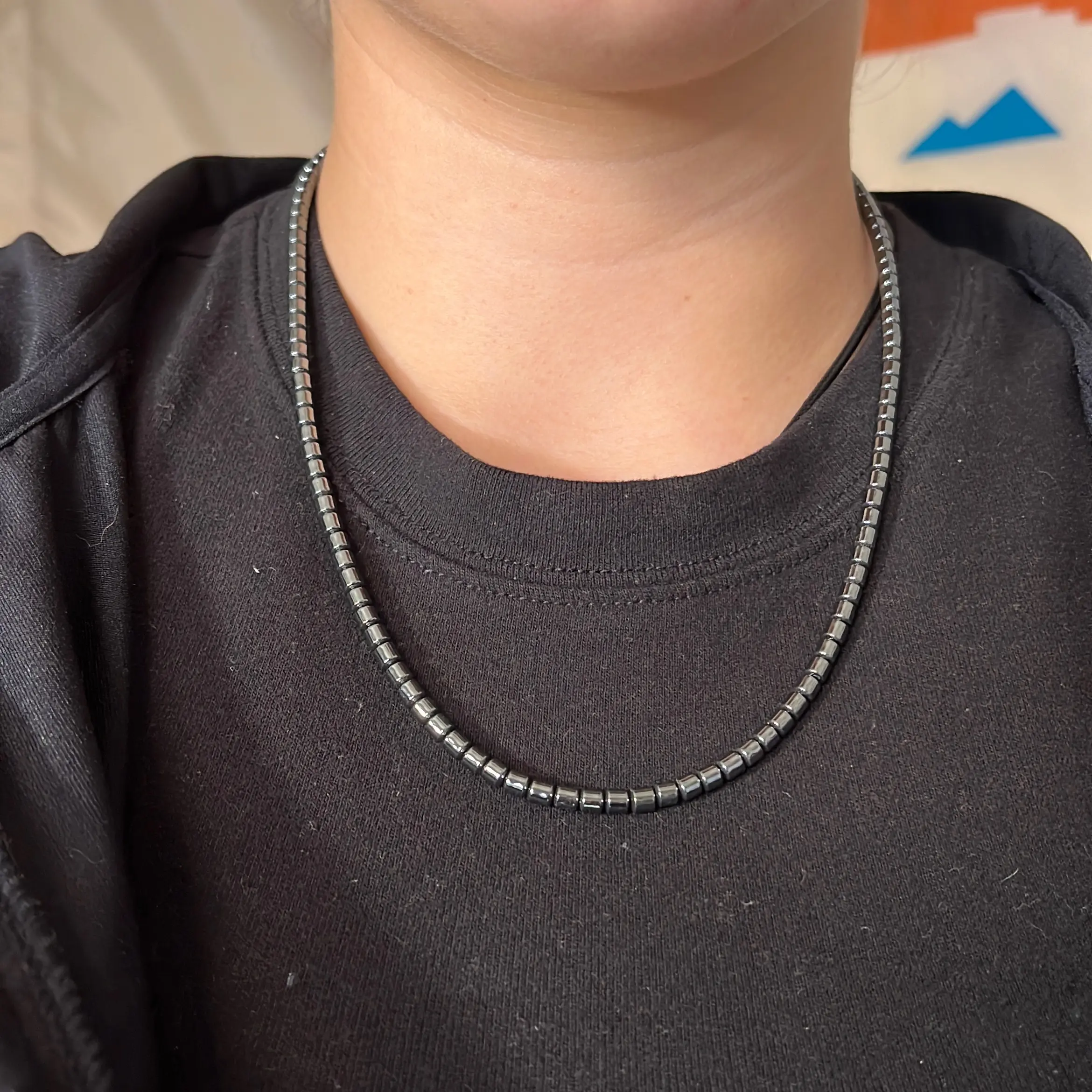 An authentic Navajo handmade necklace featuring hematite, liquid silver beads, daisy-shaped beads, and sterling silver beads of 3mm.