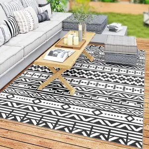 Waterproof and sun-resistant polypropylene reversible plastic woven outdoor rug with geometric patterns fitted with four corner loop straps wind stable design suitable for laying on terraces and lawns for leisure use