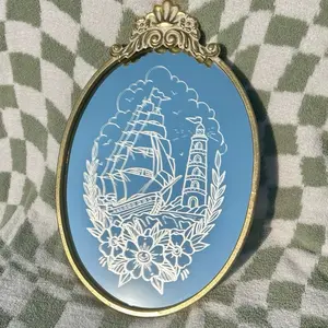 Anchored in Time – Etched Tattoo-Style Sailboat & Lighthouse Mirror | Nautical Wall Decor | Gold Frame | Traditional Flash Art | Ocean Gift