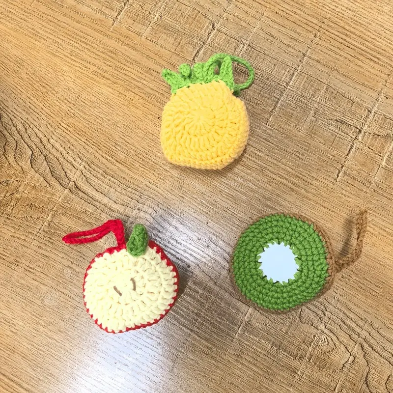 2-in-1 hand-crocheted fruit bag charm & coffee cup net pouch. Foldable water bottle holder with handle. Fits cups & bottles. Works as keychain accessory. Fruit designs: apple, pineapple