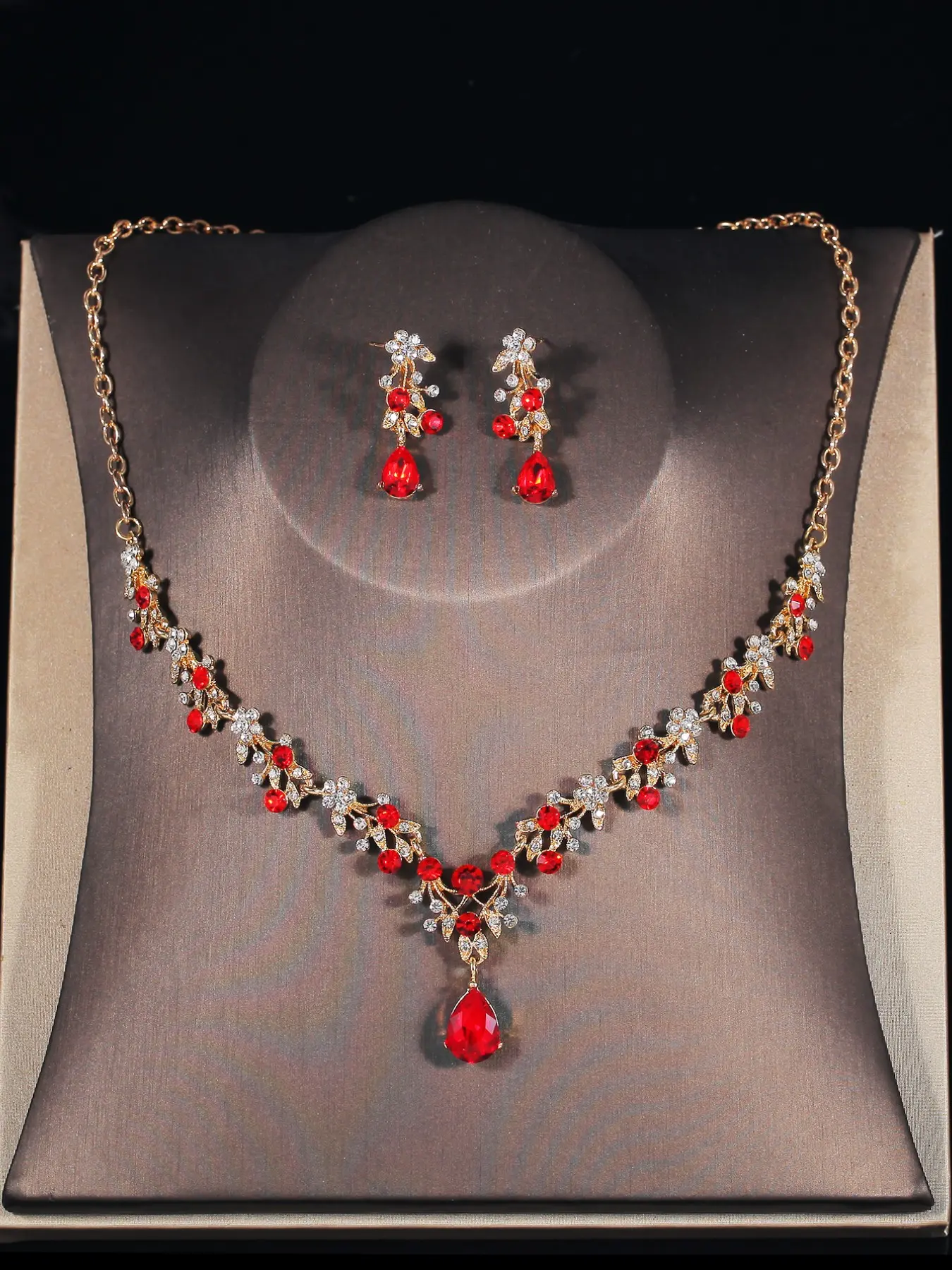 A set of red and elegant bridal accessories including a crown, crystal-encrusted necklace, and earrings, suitable for wedding dresses and also perfect for wedding parties, dances, and prom events.