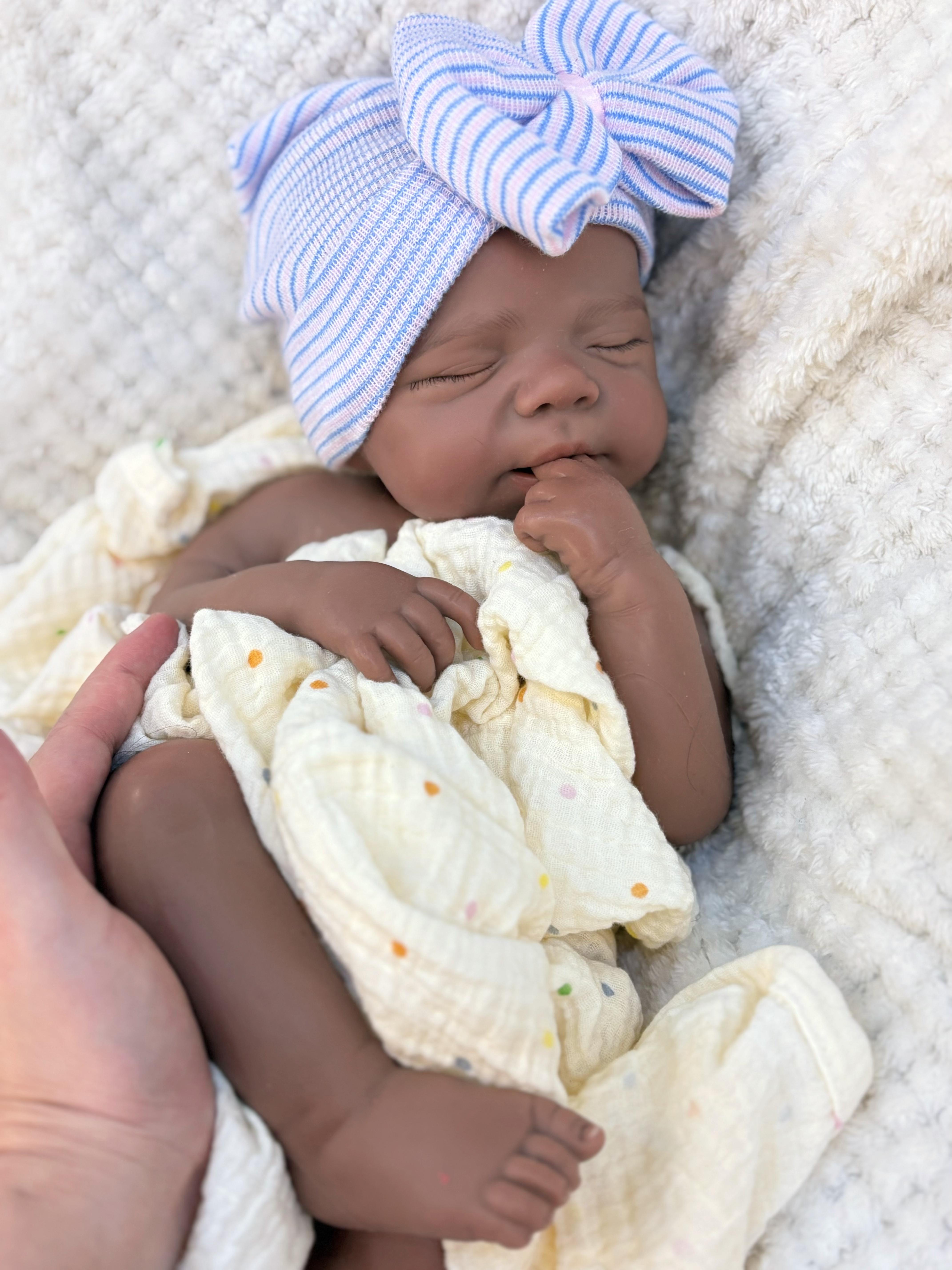Reborn doll, soft silicone — 18 inches tall, lifelike with closed eyes for sleeping, brown skin, a soft body, and realistic detailed features. Includes a comfort item, a bottle, and a birth certificate. Perfect for birthday gifts, collectors, and children