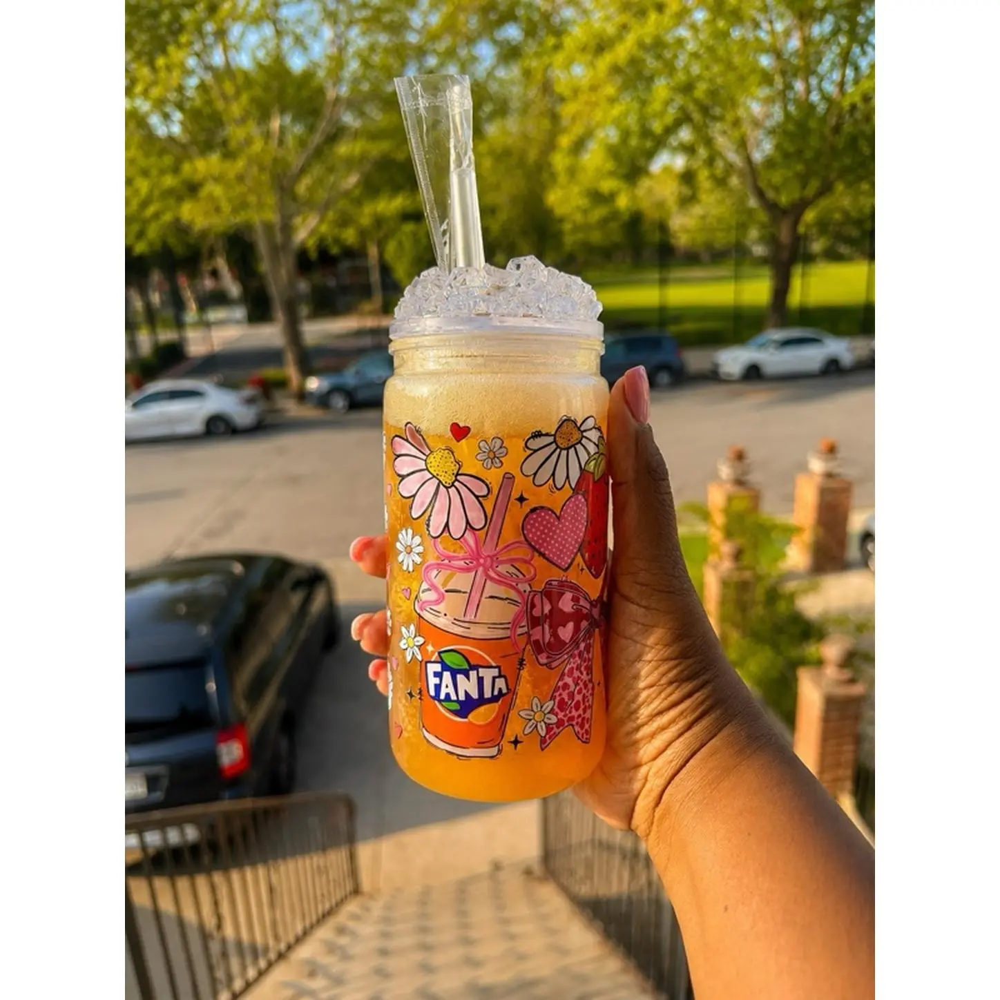 Inspired Fanta Orange Iced Beverage in a Floral Design Jar with Straw and Ice Cubes