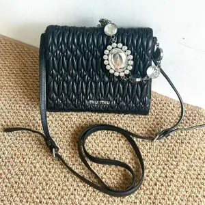 Pre-owned miu miu black chain bag with shoulder straps, can be worn on one shoulder or crossbody, featuring gemstone accents.