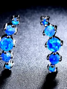 A pair of petite, round, synthetic Australian Opal ear studs with an elegant, European-inspired aesthetic, suitable for everyday use or travel, and perfect for women looking to add a touch of luxury and a cool, understated style to their accessories.