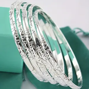 A set of five trendy silver-patterned bracelets showcasing fashionable geometric circular designs, suitable for various occasionsfine