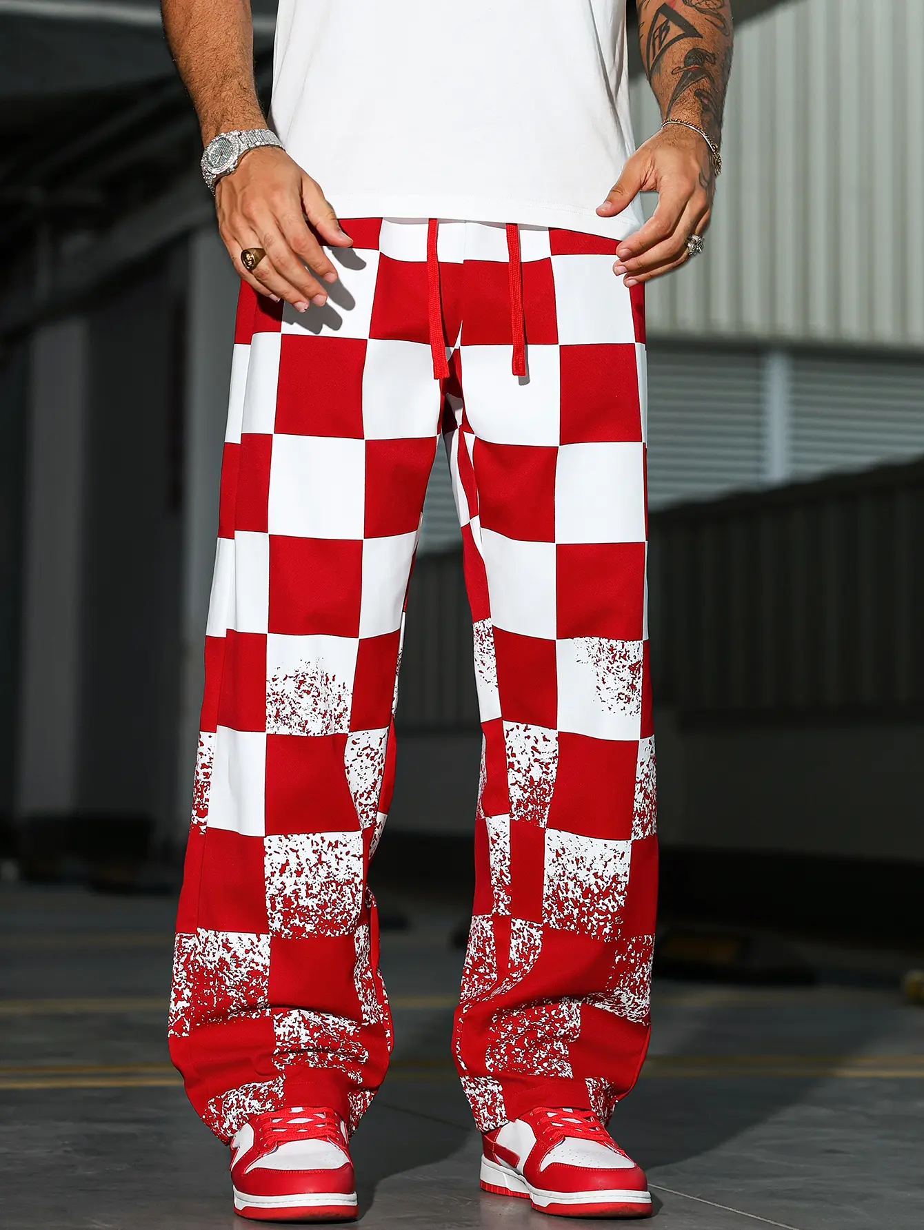 Unisex straight leg pants featuring a red and white checkerboard paint splatter pattern – smooth woven fabric, elastic waistband with natural drawstring, side pockets, relaxed flared hem, American street hip hop style for summer skating and city outings