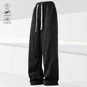 A pair of black wavy pattern drawstring casual pants, urban leisure style, black sober and low-key, matching the dressing taste of city people. The wavy texture and drawstring details add a design element to the simplicity, catering to the fast-paced urba