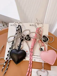 A niche, personalized, and refined ambiance pendant featuring bow and heart design elements, with braided lanyard decoration for easy portability. Versatile in use, suitable as a bag pendant or keychain, ideal for commuting and shopping