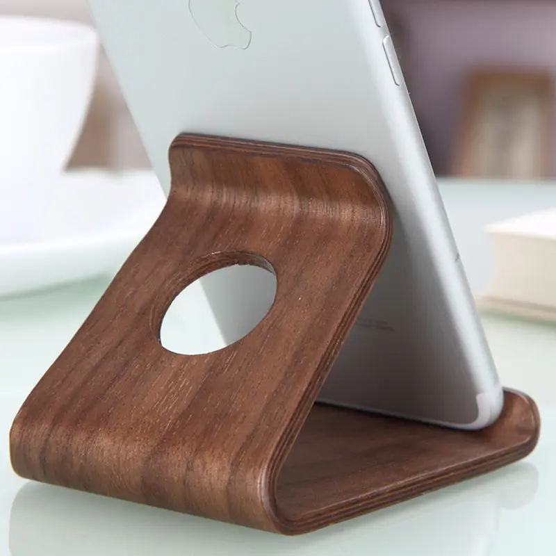 One-piece curved wooden phone display stand with charging tray for desktop use