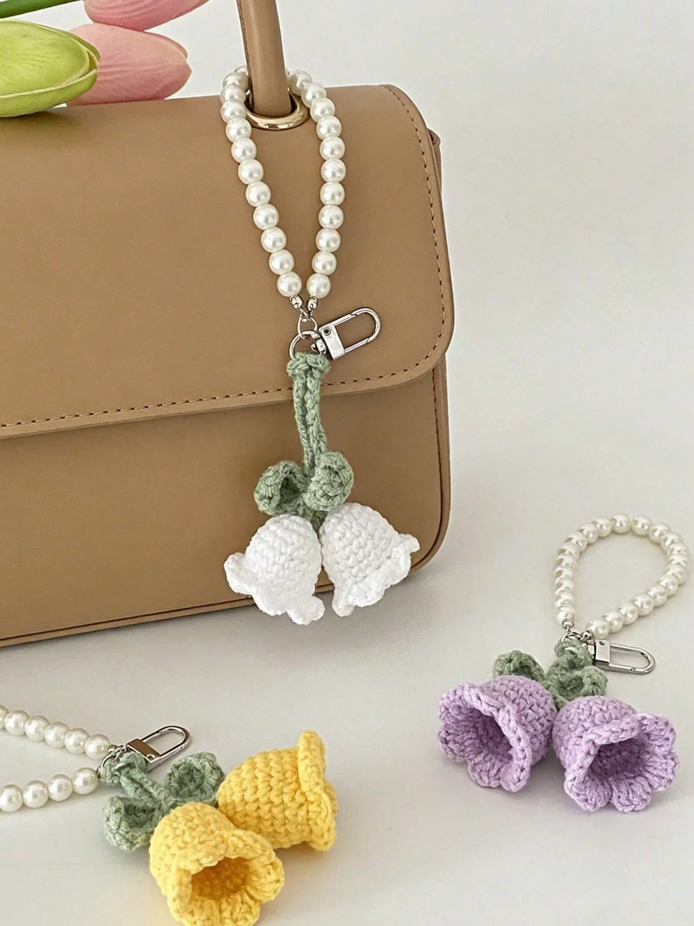 A cute handmade crocheted lily of the valley keychain, with a pearl bead chain, crocheted lily of the valley flower keychain pendant, female floral bag accessory, aesthetic floral keyring, can be used for wallets, backpacks, and car keys