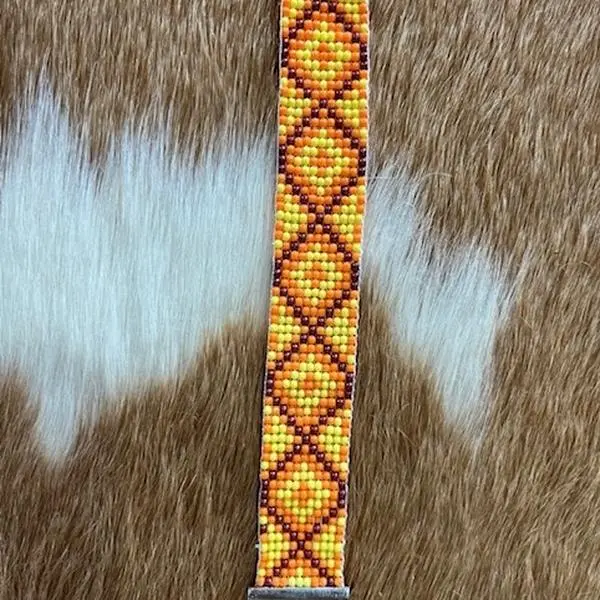Orange Yellow Brown Handmade Native Bracelet with Unique Bead Design on Fur Background